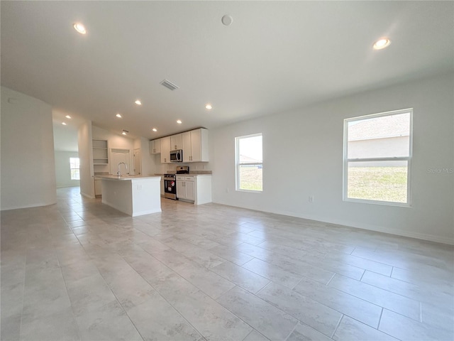 1212 Caloosa Ridge Ave, Babson Park, FL 33827 - unfurnished living room featuring a sink, vaulted ceiling, and recessed lighting