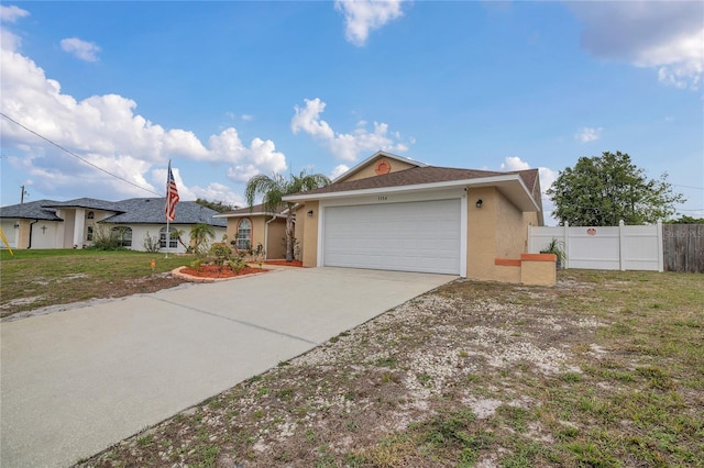 ranch-style house with a garage, fence, driveway, stucco siding, and a front lawn