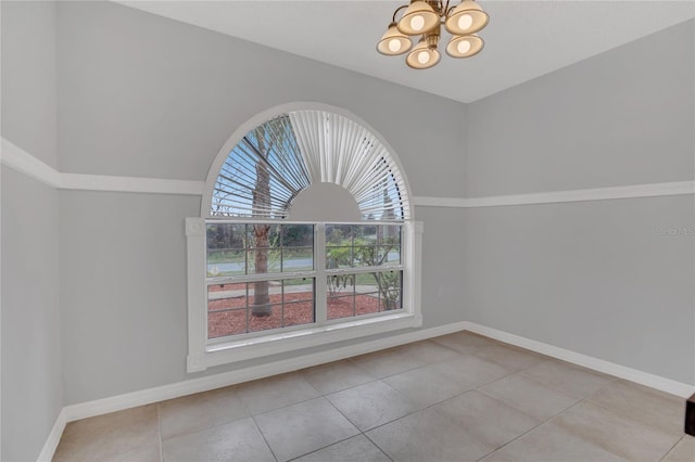 interior space featuring light tile patterned flooring, a notable chandelier, and baseboards