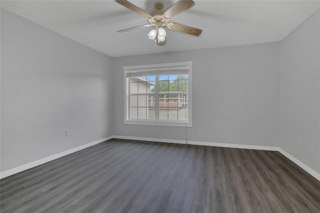 unfurnished room with dark wood-style floors, ceiling fan, a textured ceiling, and baseboards