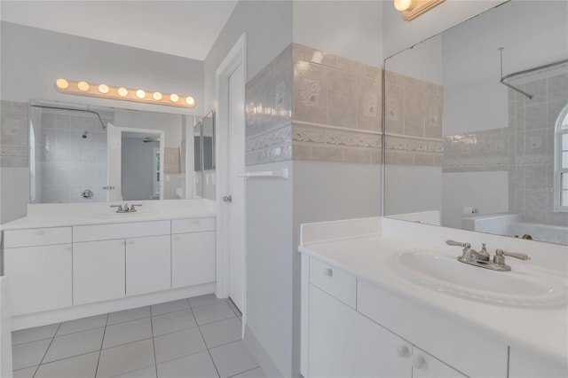 full bathroom featuring tile patterned flooring, two vanities, a sink, and tiled shower