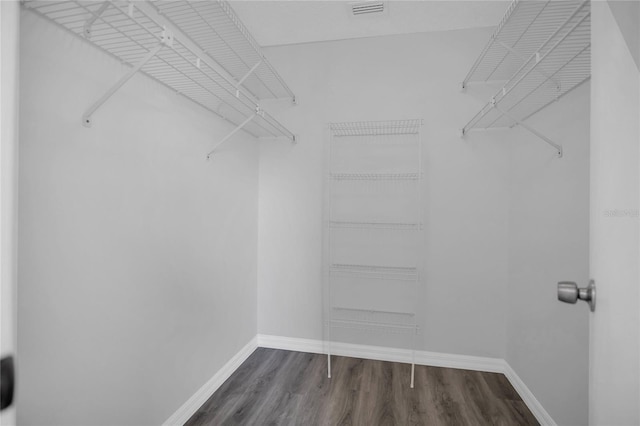 walk in closet with dark wood-style floors and visible vents