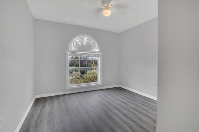 empty room featuring dark wood-type flooring, baseboards, and a ceiling fan