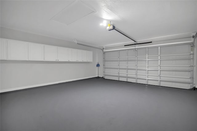 garage featuring a garage door opener and baseboards