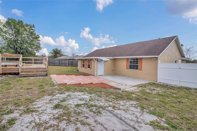 back of house featuring a yard, stucco siding, a patio area, a deck, and a fenced backyard