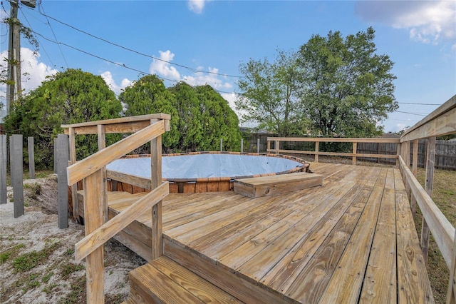 wooden terrace with a fenced backyard