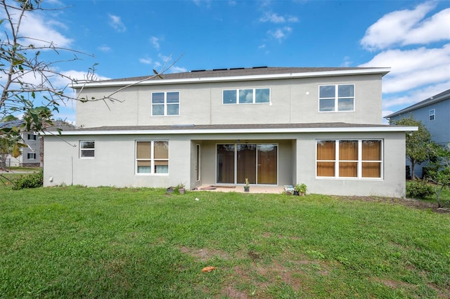 back of house featuring a yard and stucco siding