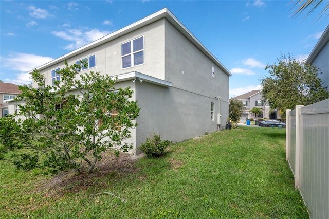 view of home's exterior with a lawn and stucco siding