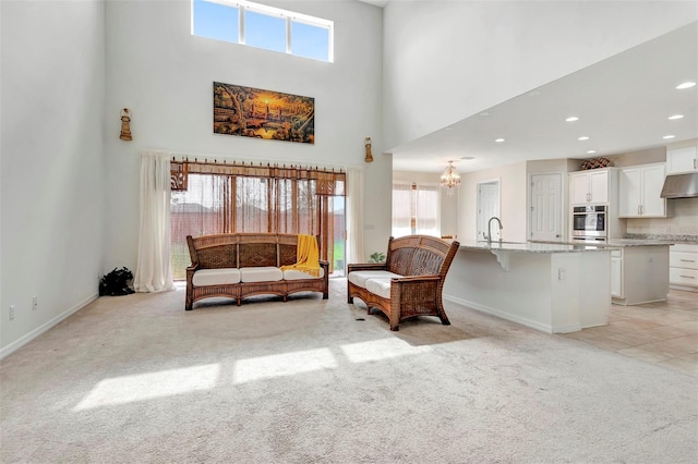 living area with baseboards, light colored carpet, and a high ceiling