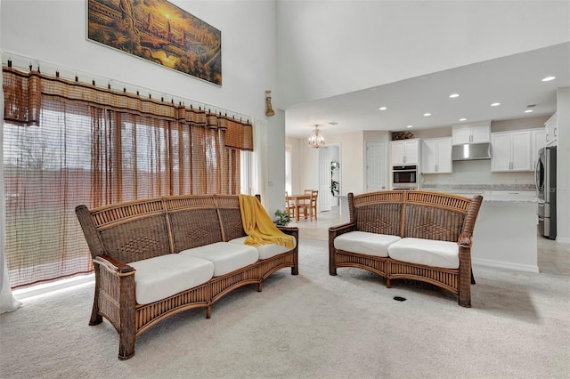 living area featuring a chandelier, recessed lighting, light colored carpet, and a high ceiling