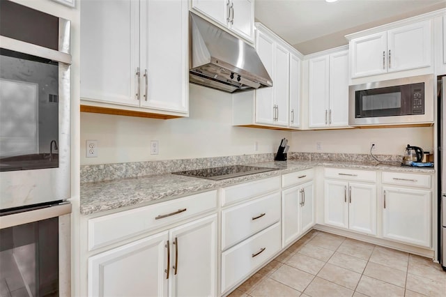 kitchen with light tile patterned floors, black electric stovetop, under cabinet range hood, white cabinetry, and built in microwave