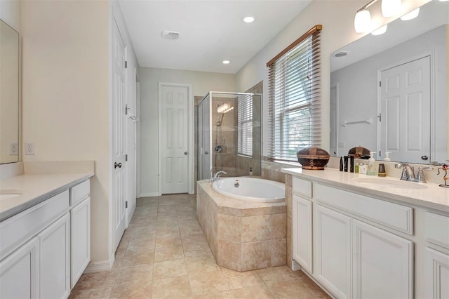 bathroom featuring a stall shower, tile patterned floors, a sink, a garden tub, and two vanities