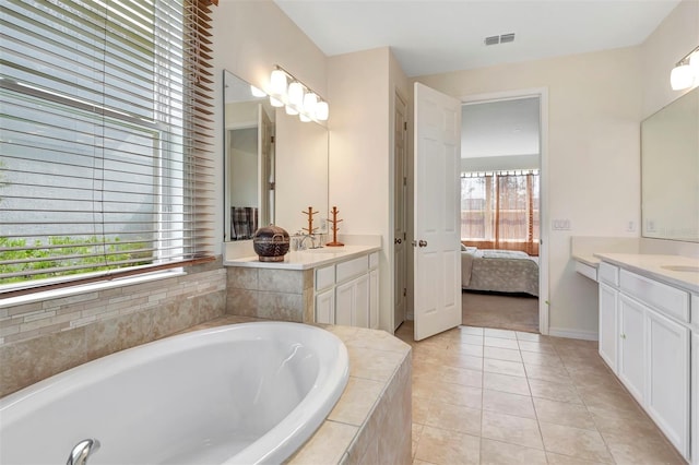 full bathroom featuring two vanities, visible vents, a garden tub, and tile patterned floors