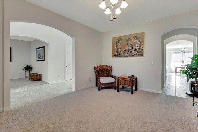 sitting room featuring carpet, arched walkways, a notable chandelier, and tile patterned floors