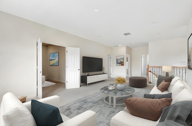 living area featuring light colored carpet and visible vents