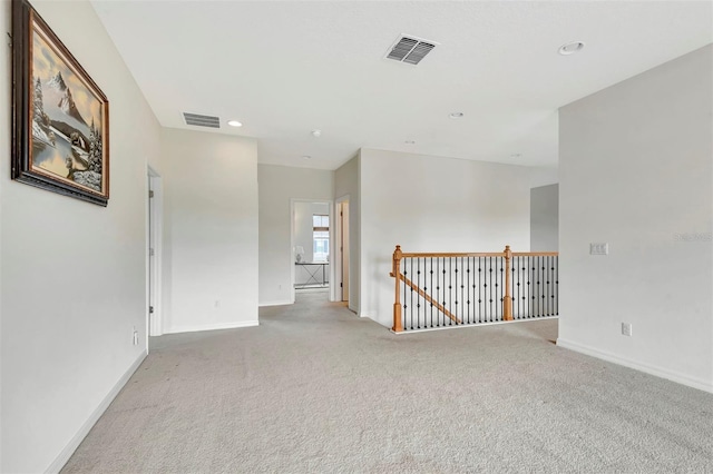 unfurnished room featuring baseboards, visible vents, and carpet flooring