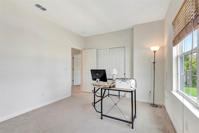 home office featuring light carpet, baseboards, visible vents, and a healthy amount of sunlight