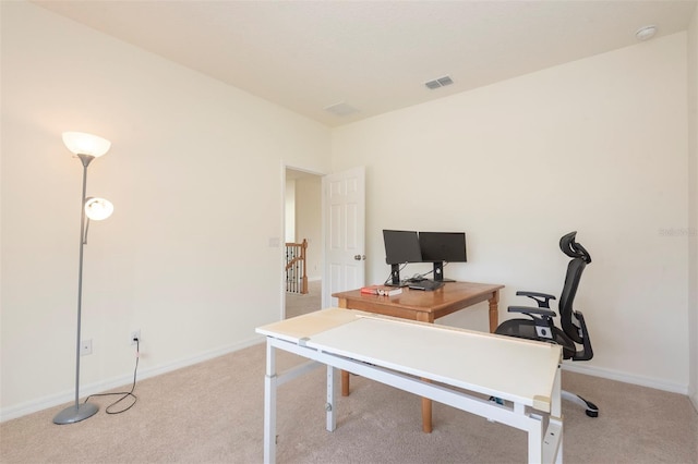 office area with baseboards, visible vents, and light colored carpet