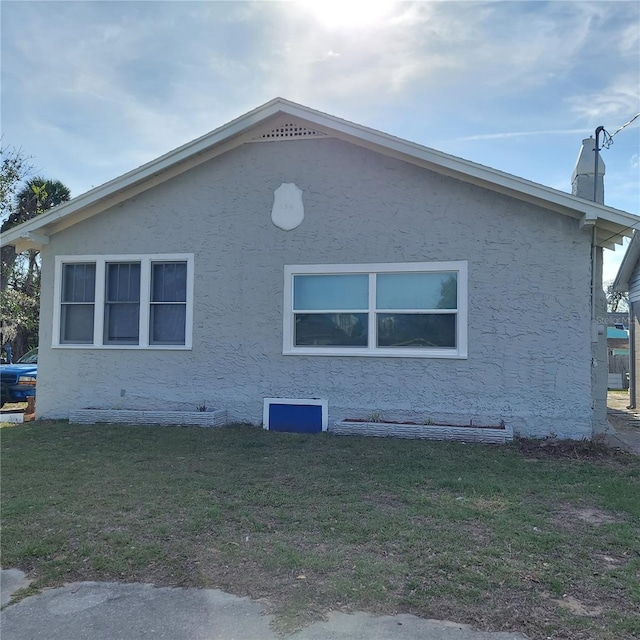 view of property exterior featuring a lawn and stucco siding