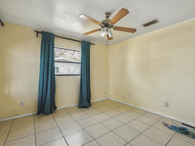 spare room with light tile patterned floors, visible vents, baseboards, and a ceiling fan