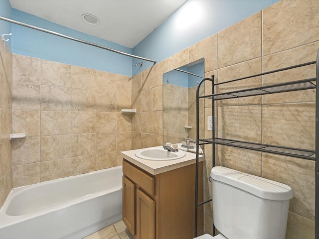 bathroom with tile patterned flooring, tile walls, shower / washtub combination, toilet, and vanity