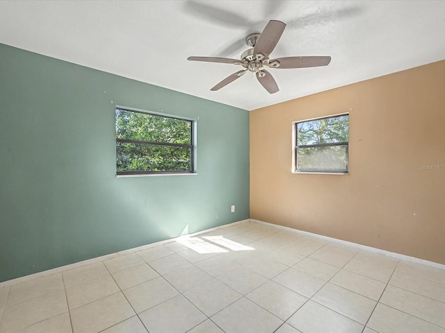 unfurnished room featuring baseboards, a ceiling fan, and tile patterned flooring