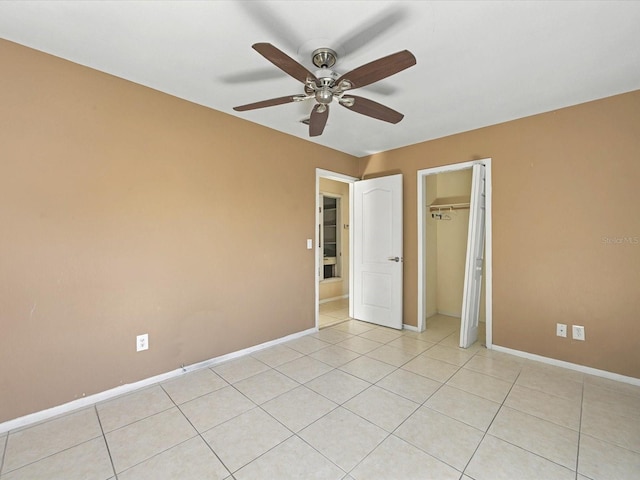 unfurnished bedroom with light tile patterned flooring, ceiling fan, baseboards, and a closet