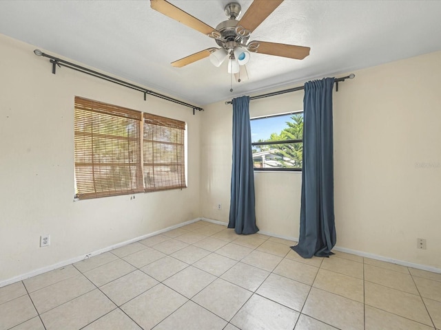 unfurnished room with light tile patterned floors, baseboards, and ceiling fan