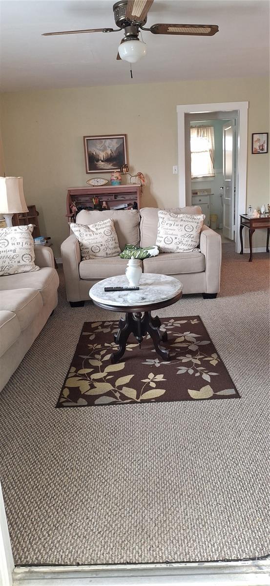 living room featuring carpet floors and a ceiling fan