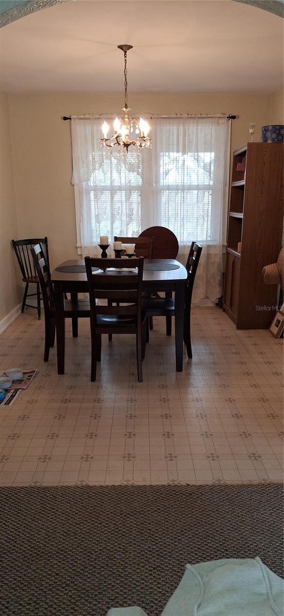 dining area with carpet floors, visible vents, and an inviting chandelier