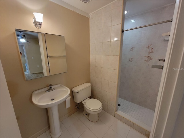 bathroom featuring visible vents, baseboards, tiled shower, toilet, and tile patterned flooring