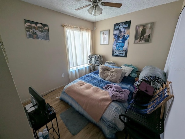 bedroom with a textured ceiling, wood finished floors, a ceiling fan, and baseboards