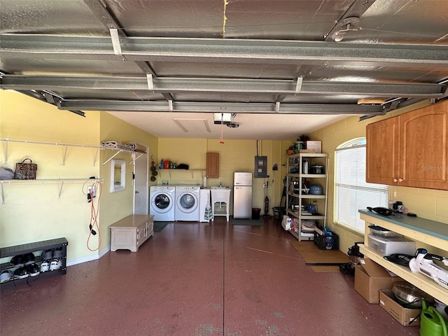 garage with concrete block wall, electric panel, a garage door opener, freestanding refrigerator, and washer and dryer