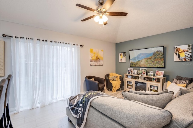 living room featuring a ceiling fan and a wealth of natural light