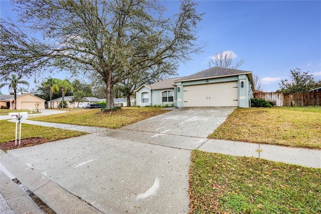 ranch-style home featuring a garage, driveway, a front yard, and fence