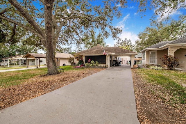 view of front of home with concrete driveway, a chimney, and a front yard