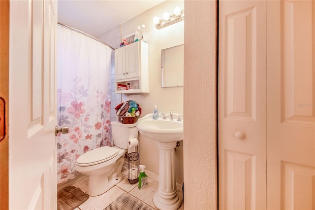 bathroom featuring curtained shower, toilet, and tile patterned floors