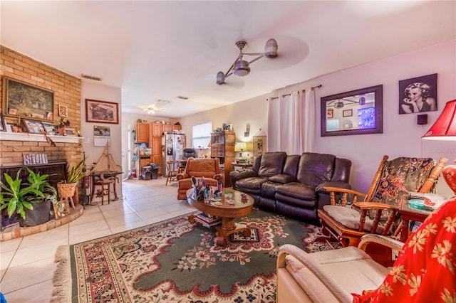 living area featuring light tile patterned flooring, a fireplace, and visible vents