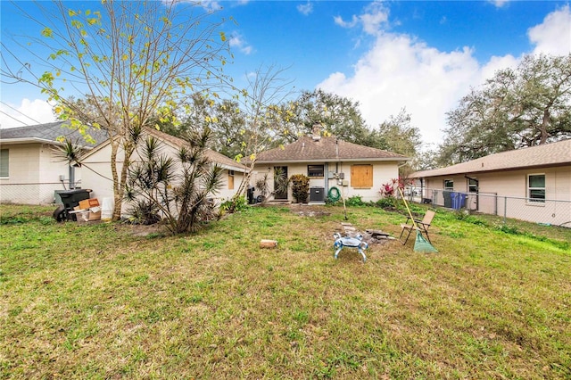 rear view of property with a yard, cooling unit, and fence