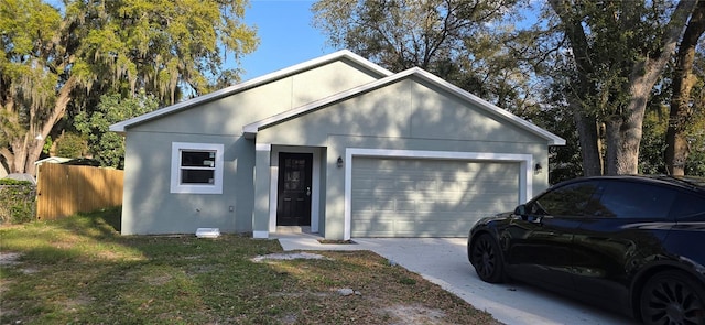 ranch-style home featuring a garage, fence, driveway, stucco siding, and a front yard