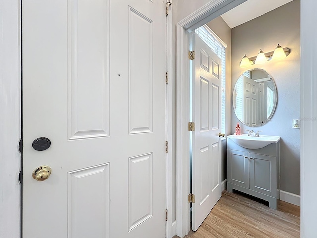 bathroom featuring vanity, baseboards, and wood finished floors