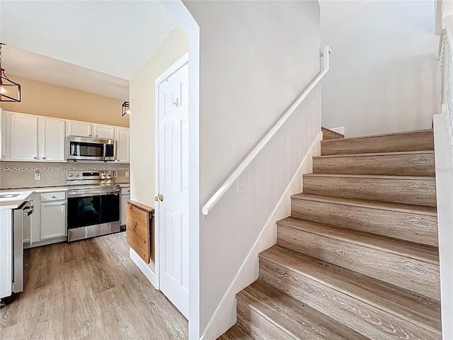 stairs featuring wood finished floors