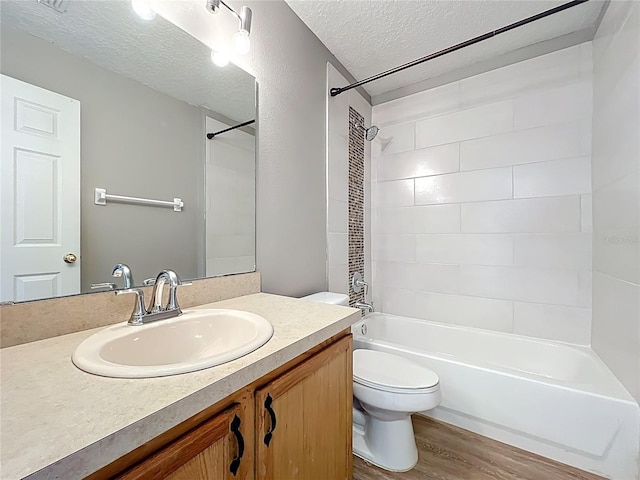 full bathroom with vanity, a textured ceiling, wood finished floors, shower / bath combination, and toilet