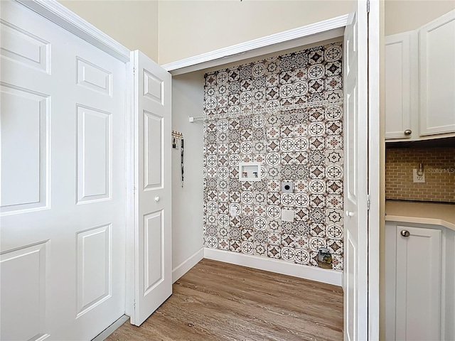 room details with decorative backsplash, wood finished floors, and baseboards