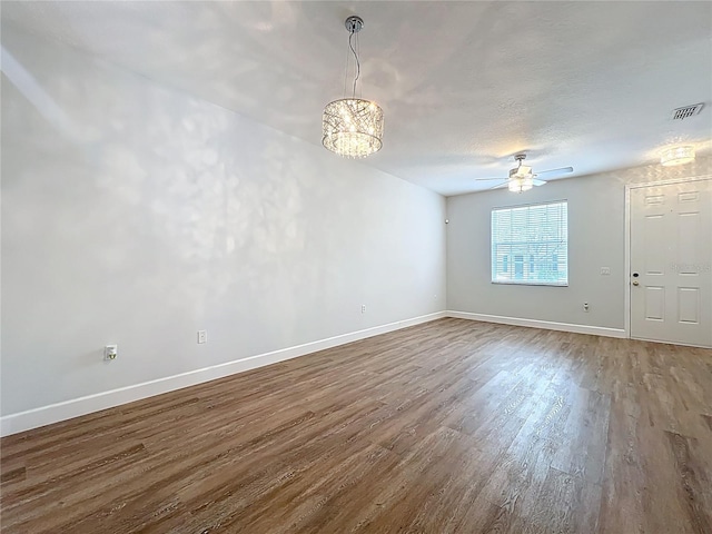 spare room with a ceiling fan, wood finished floors, visible vents, baseboards, and a textured ceiling