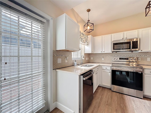 kitchen with light countertops, backsplash, appliances with stainless steel finishes, and a sink