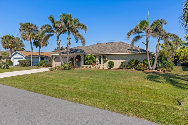 ranch-style home with concrete driveway, a front lawn, an attached garage, and stucco siding