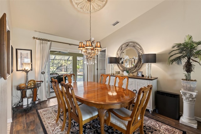 dining area with wood finished floors, visible vents, baseboards, vaulted ceiling, and an inviting chandelier