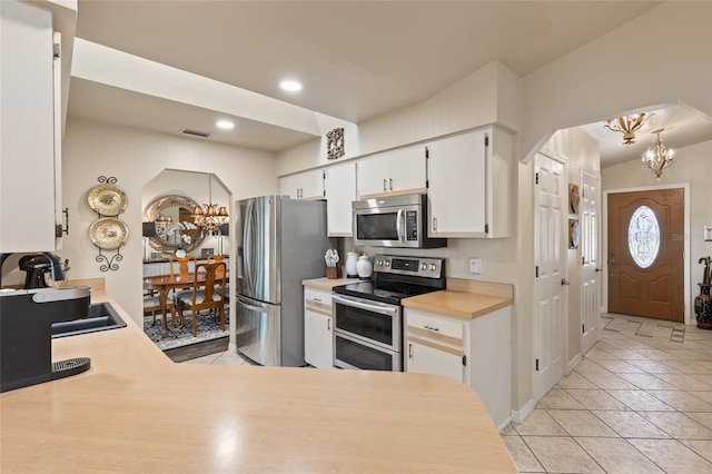 kitchen with arched walkways, a chandelier, visible vents, light countertops, and appliances with stainless steel finishes