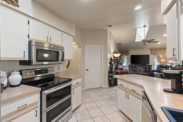 kitchen featuring ceiling fan, light countertops, appliances with stainless steel finishes, and white cabinetry